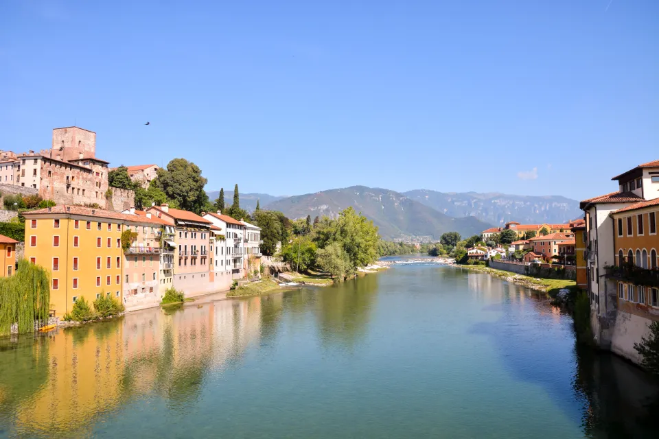 Historic houses of Bassano del Grappa along the Brenta river, with the mountains behind