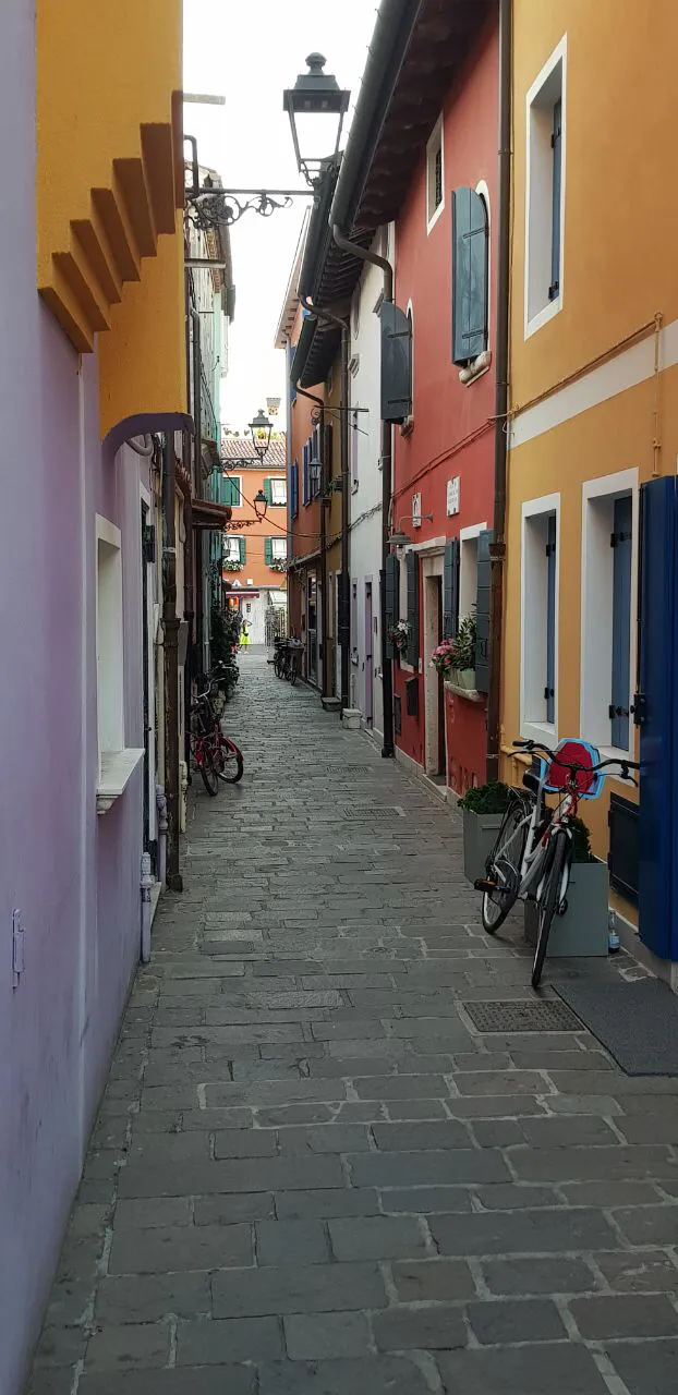 Narrow calle lined with colourful houses in Caorle's old town
