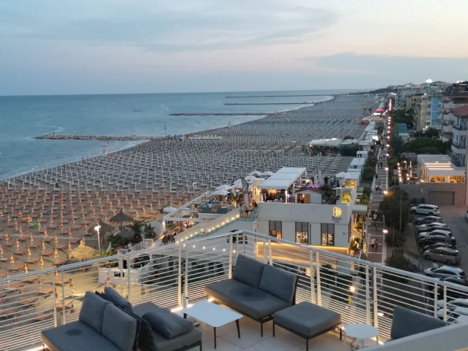 Hotel terrace overlooking a wide Adriatic beach at sunset