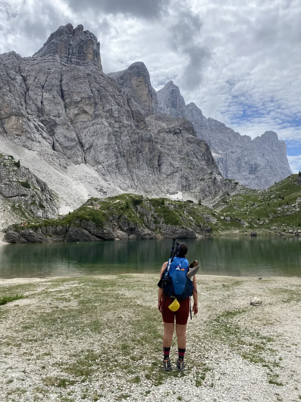 Hiker looking across Lake Coldai towards the Civetta
