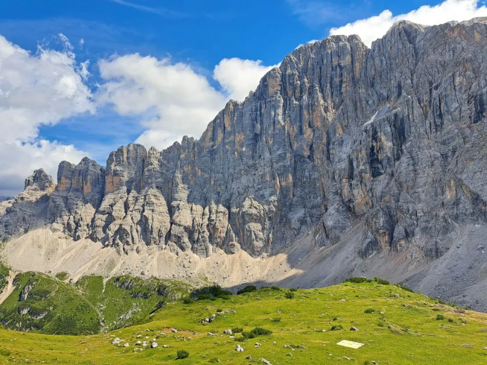 The great rock wall of the Civetta above green alpine pastures