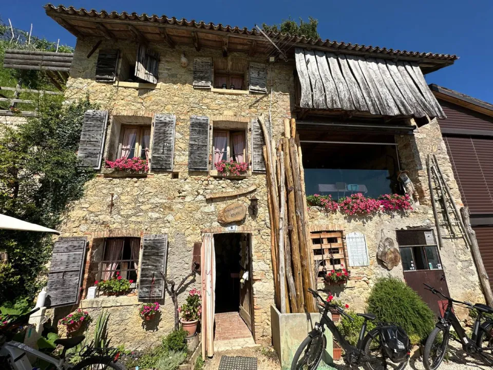 Rustic stone farmhouse with flower boxes and e-bikes in the Prosecco Hills