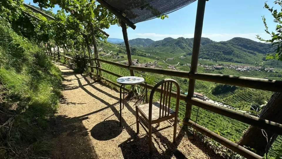 Table and chair on a shaded terrace overlooking the Prosecco vineyards